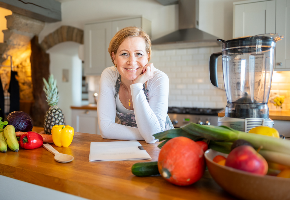Frau in der Küche lächelt in die Kamera
