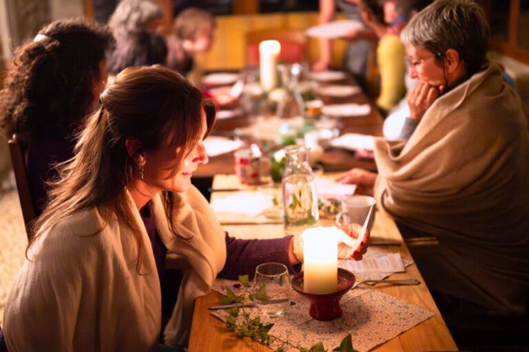 Lange Tafel mit Gästen mit Kerzenschein